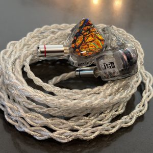 SymphonyEars Hexad II IEMs with dichroic fire faceplates resting on their braided silver cable